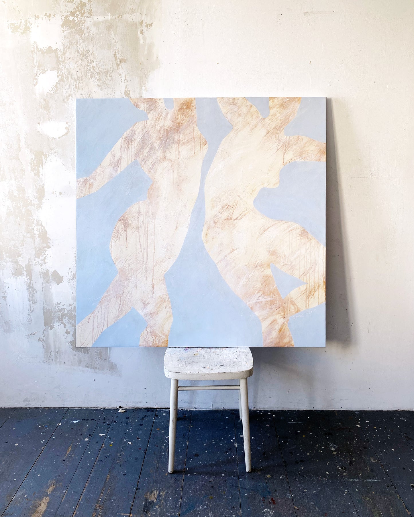 Abstract art piece with two figures on a light blue background, placed on a white stool against a textured wall / large canvas, acrylic on canvas, oversized wall art, abstract art, Anna Pepe, forn Studio