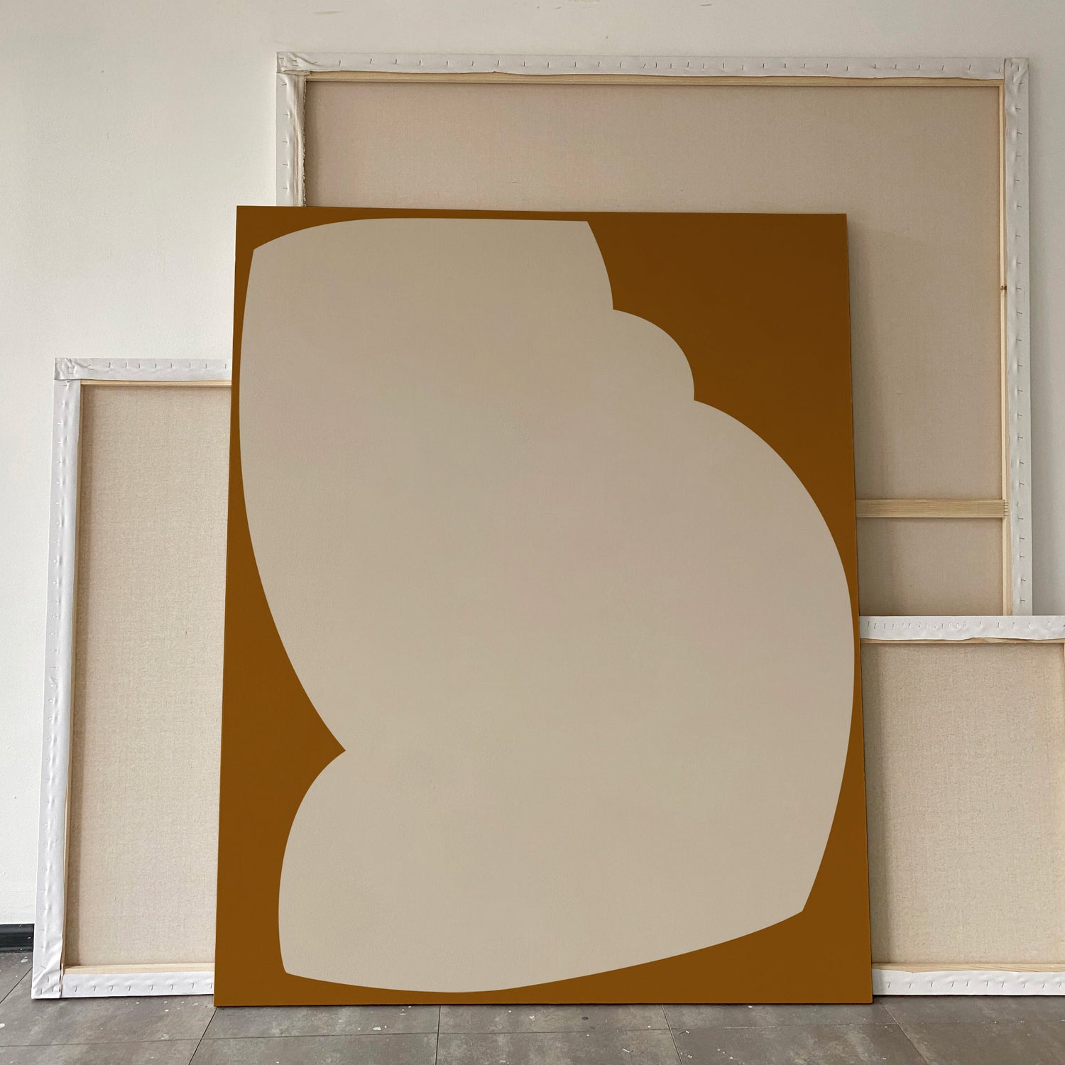 Abstract art piece with a beige shape on a brown background, framed in white. large canvas, acrylic on canvas, oversized wall art, abstract art, Anna Pepe, forn Studio