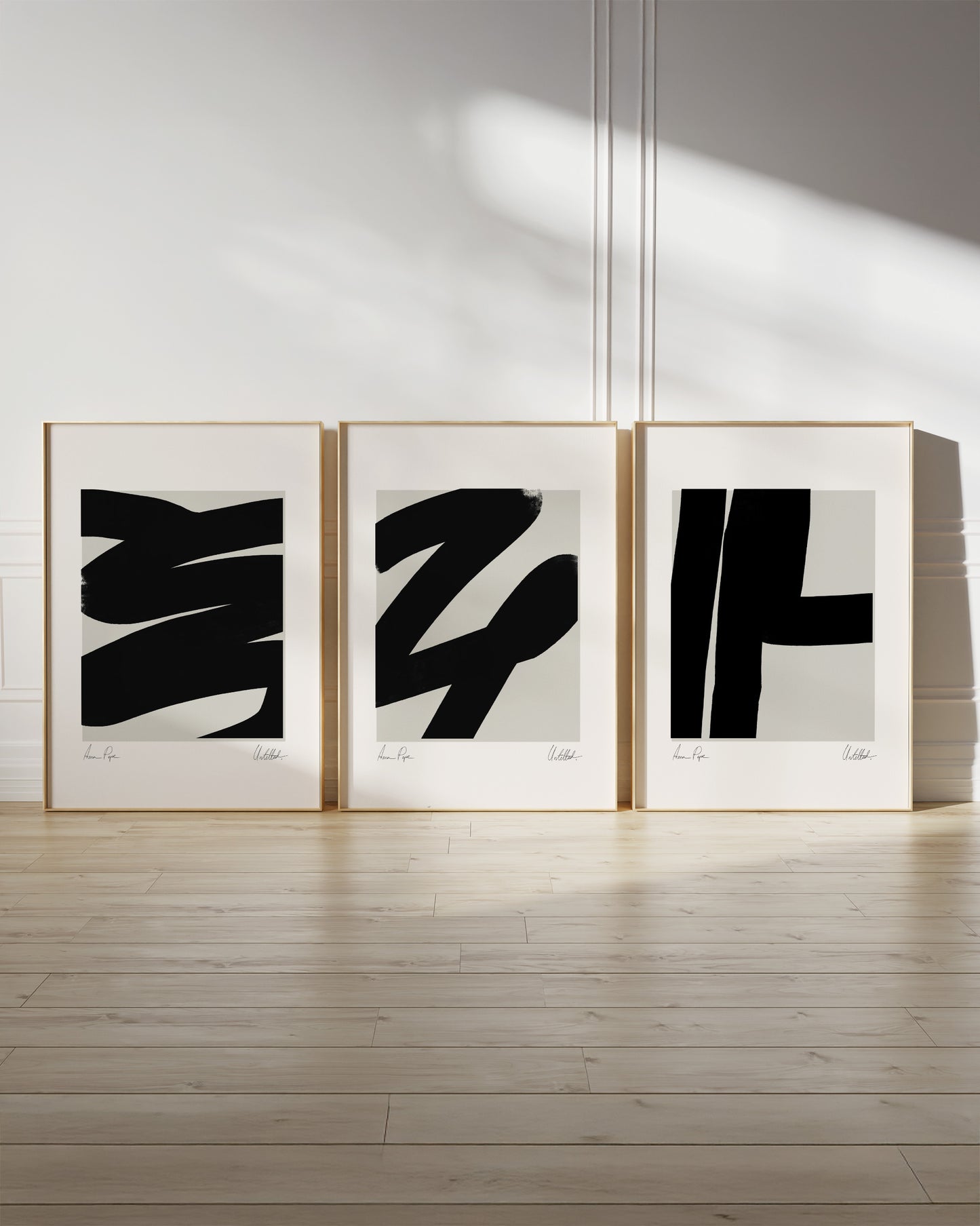 Three abstract art prints in frames on a white wall with wooden floor. anna pepe, artist, contemporary art, printed wall art, framed prints, modern interior decor