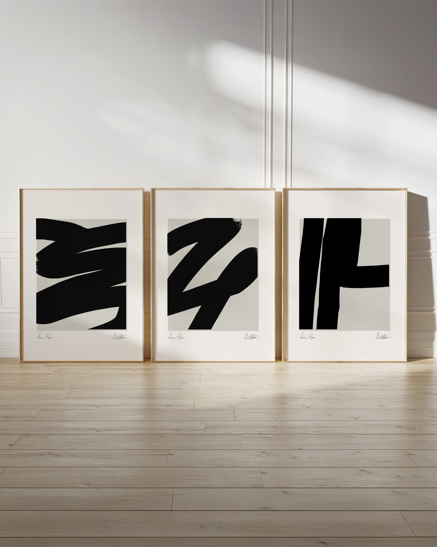 Three abstract art prints in frames on a white wall with wooden floor. anna pepe, artist, contemporary art, printed wall art, framed prints, modern interior decor