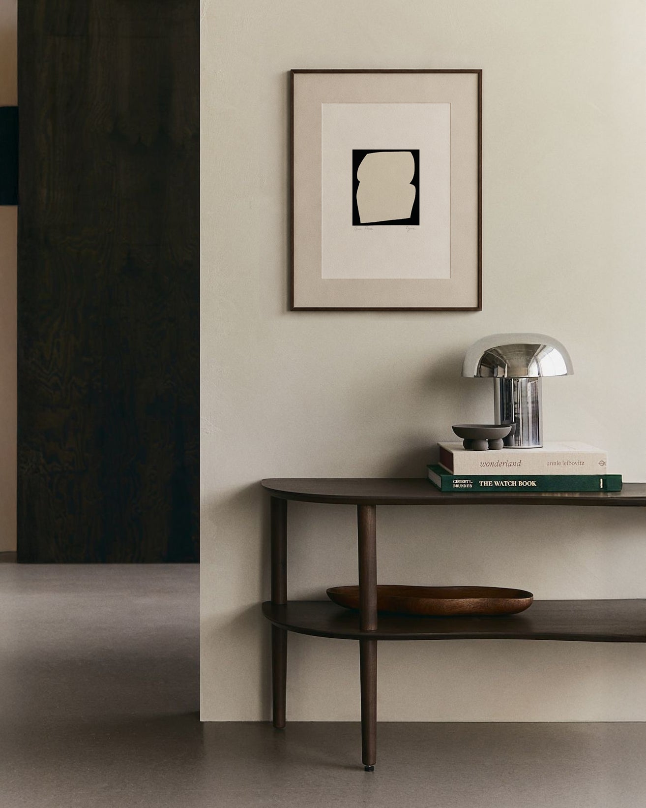 Modern interior with a dark wooden console table against a light wall, featuring a framed abstract art piece. artist anna pepe, forn studio, abstract painting, small art work, female abstract form