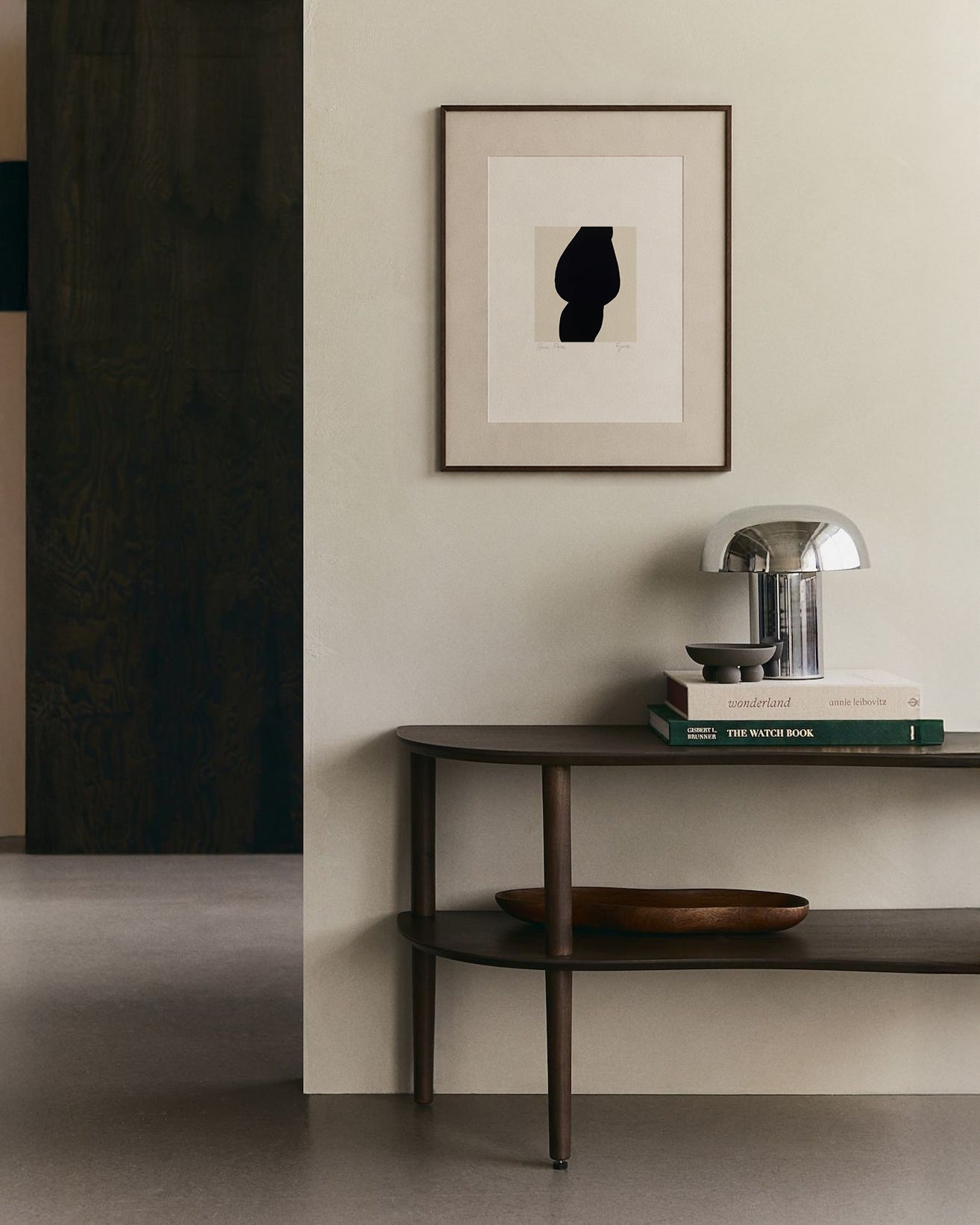 Modern interior with a dark wooden console table against a light wall, featuring a framed abstract art piece. artist anna pepe, forn studio, abstract painting, small art work, female abstract form